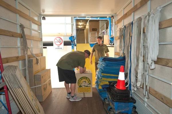Two Man and His Van removalists moving furniture out of pre-packed boxes in a storage locker on Sydney's Northern Beaches.