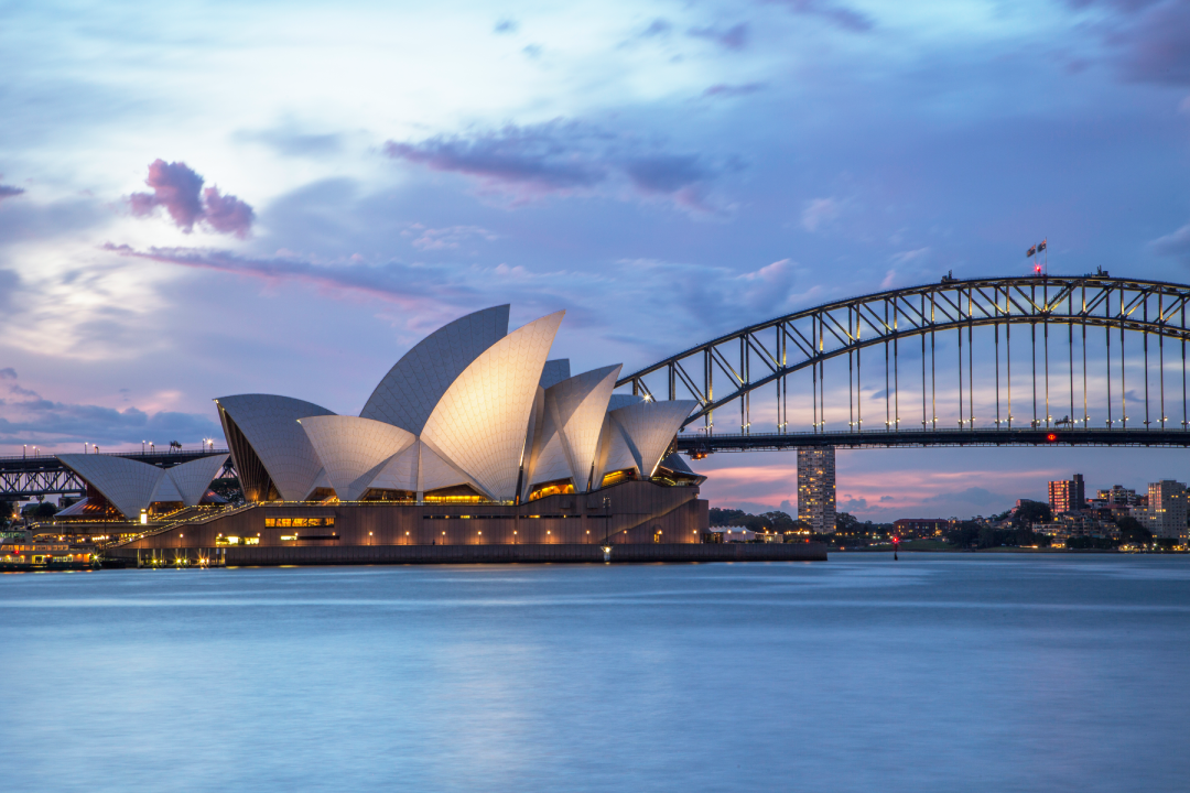 Sydney Opera House and Harbour Bridge across the water at dusk