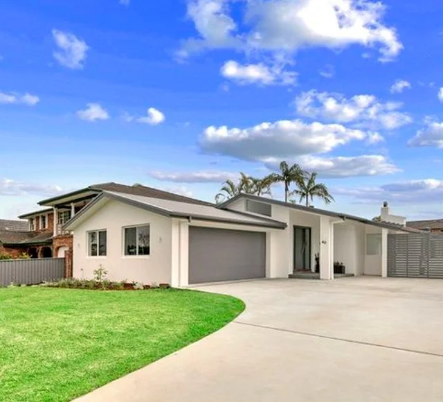 Single-storey home with a double garage, broad driveway and neatly maintained front lawn.